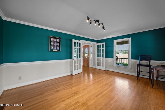 interior space featuring french doors, light hardwood / wood-style flooring, ornamental molding, and track lighting