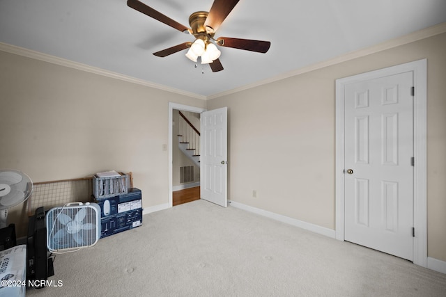 interior space featuring crown molding, ceiling fan, and light colored carpet