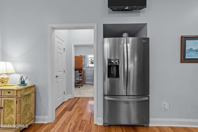 kitchen with stainless steel fridge, light wood finished floors, and baseboards