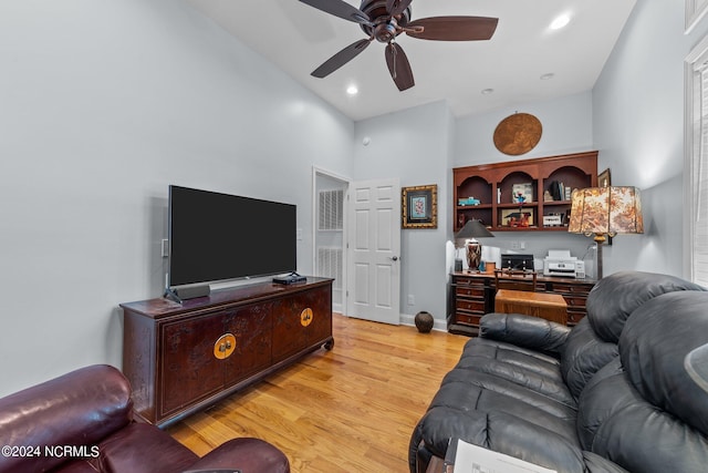 living room featuring ceiling fan, light hardwood / wood-style flooring, and high vaulted ceiling