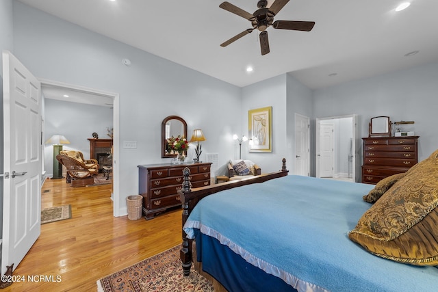 bedroom featuring a fireplace, recessed lighting, baseboards, and light wood-style flooring