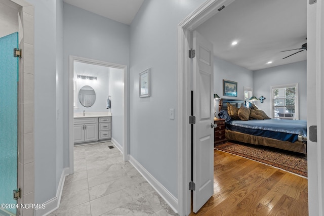 bedroom with ensuite bath and light hardwood / wood-style floors