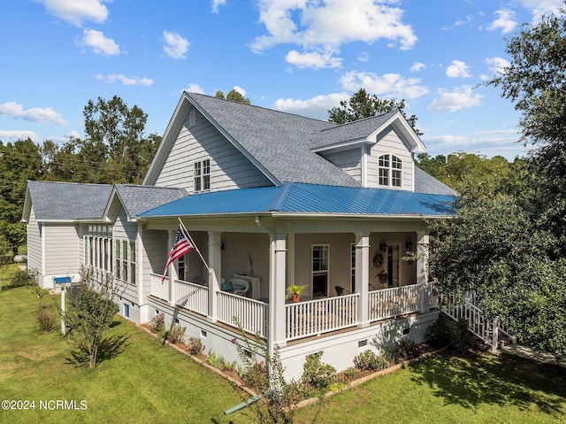 farmhouse-style home with crawl space, covered porch, a front yard, and metal roof