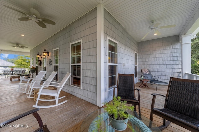 deck with outdoor dining space, ceiling fan, and covered porch