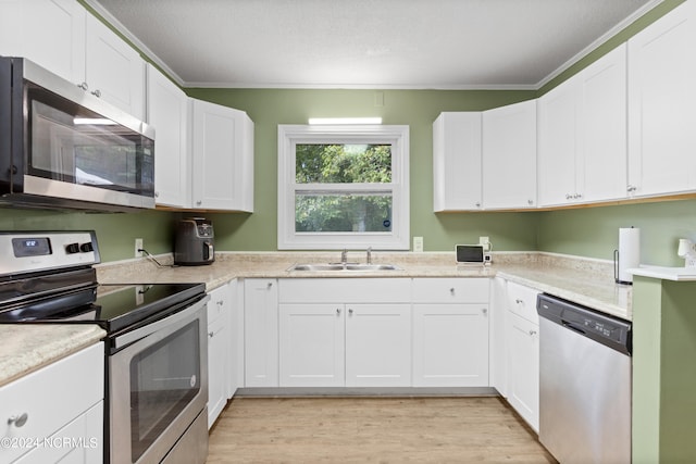 kitchen with white cabinetry, sink, and stainless steel appliances