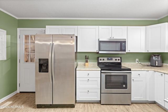 kitchen with light hardwood / wood-style flooring, stainless steel appliances, white cabinetry, and crown molding