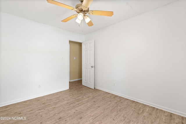 empty room with ceiling fan and light hardwood / wood-style flooring