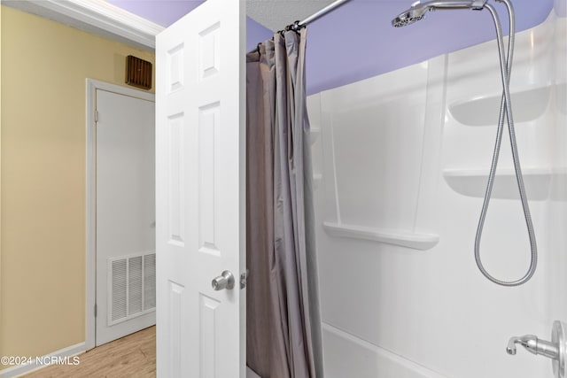 bathroom featuring curtained shower and hardwood / wood-style flooring