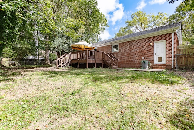 rear view of property with a deck and a yard