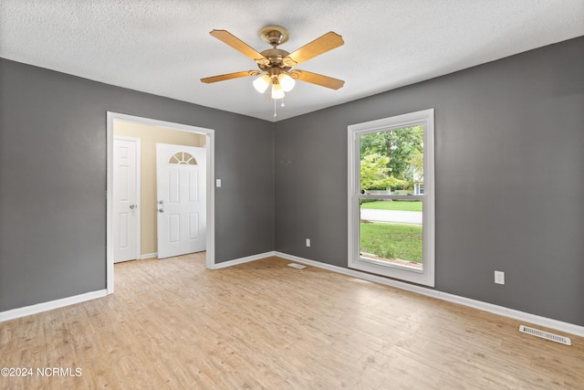 unfurnished room with light hardwood / wood-style floors, ceiling fan, and a textured ceiling