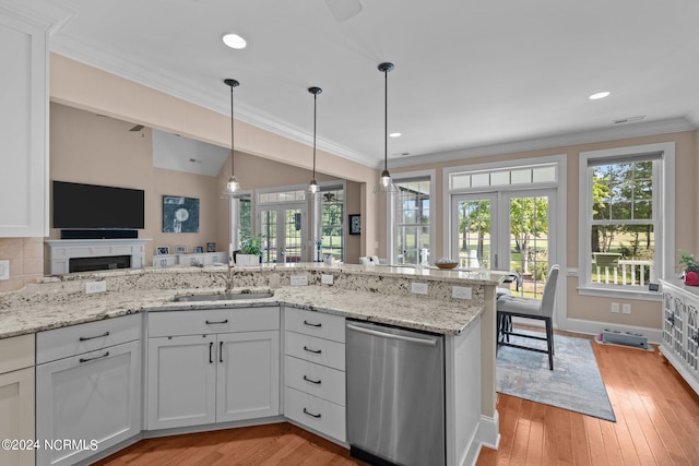 kitchen with light hardwood / wood-style floors, white cabinets, light stone countertops, french doors, and stainless steel dishwasher