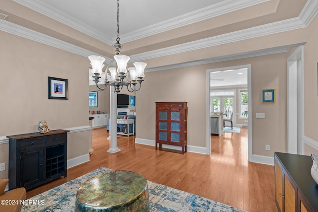 living room featuring wood-type flooring, decorative columns, ornamental molding, and a notable chandelier