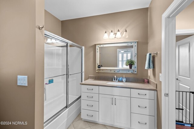 bathroom featuring enclosed tub / shower combo, vanity, and tile patterned floors