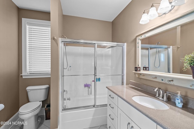 full bathroom featuring bath / shower combo with glass door, vanity, tile patterned flooring, and toilet