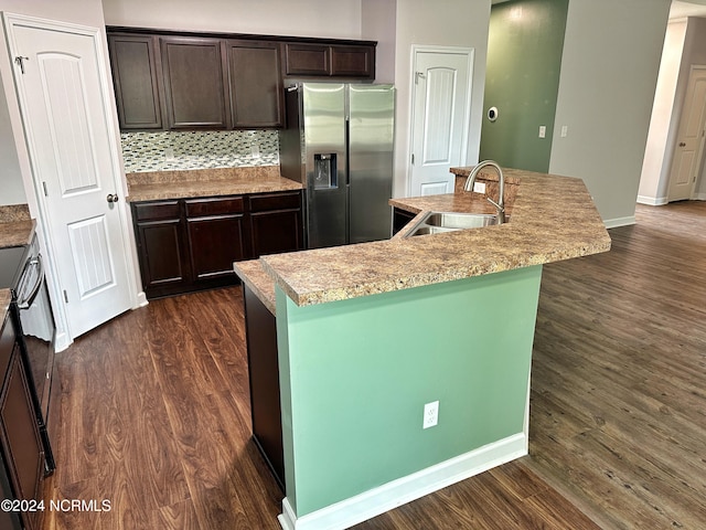 kitchen featuring dark brown cabinets, stainless steel refrigerator with ice dispenser, a center island with sink, and sink