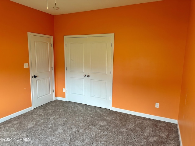 unfurnished bedroom featuring carpet floors and a closet