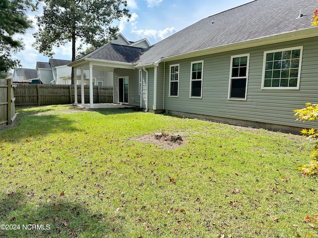 rear view of house featuring a patio and a yard