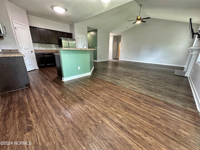 kitchen featuring dark hardwood / wood-style floors, lofted ceiling, stainless steel refrigerator, backsplash, and dark brown cabinetry