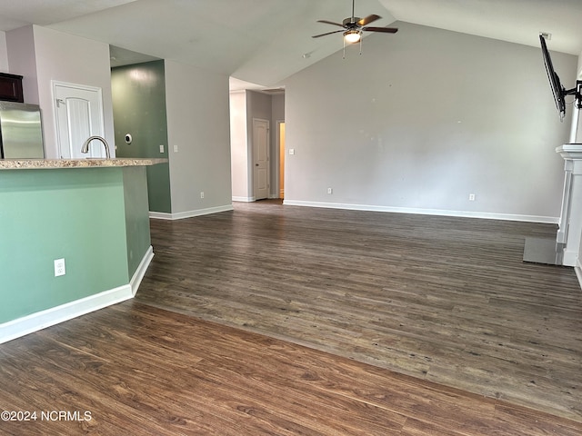 unfurnished living room featuring ceiling fan, sink, dark hardwood / wood-style floors, and vaulted ceiling