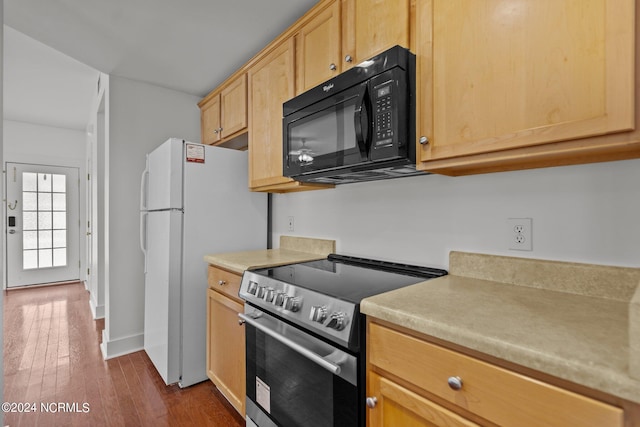 kitchen with stainless steel range, hardwood / wood-style flooring, light brown cabinets, and white fridge