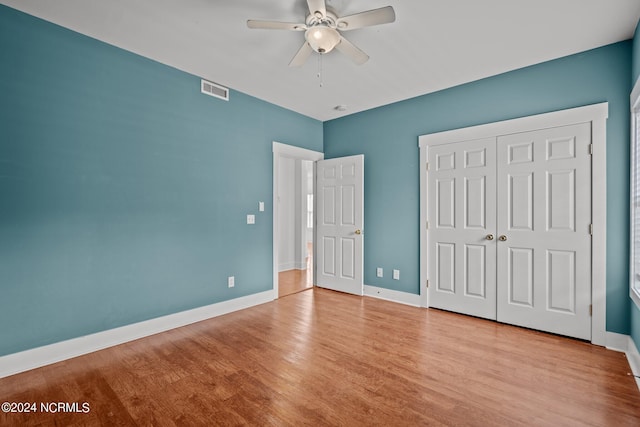 unfurnished bedroom with a closet, light hardwood / wood-style floors, and ceiling fan