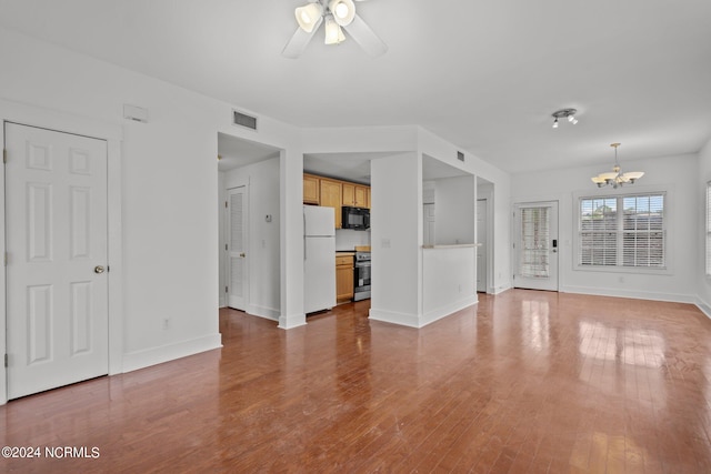 unfurnished living room with wood-type flooring and ceiling fan with notable chandelier