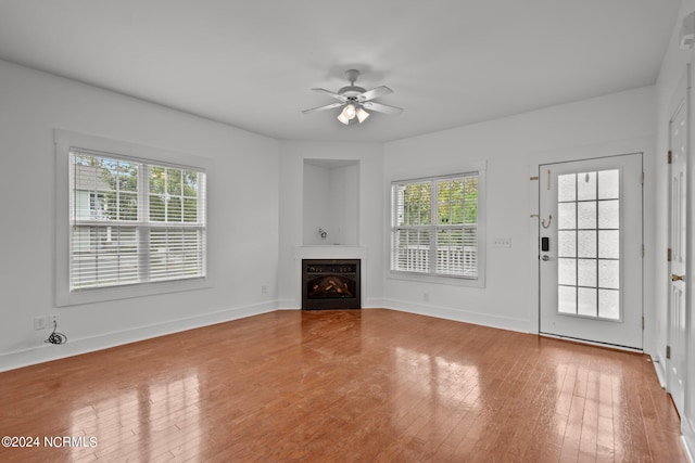 unfurnished living room with ceiling fan, plenty of natural light, and hardwood / wood-style floors