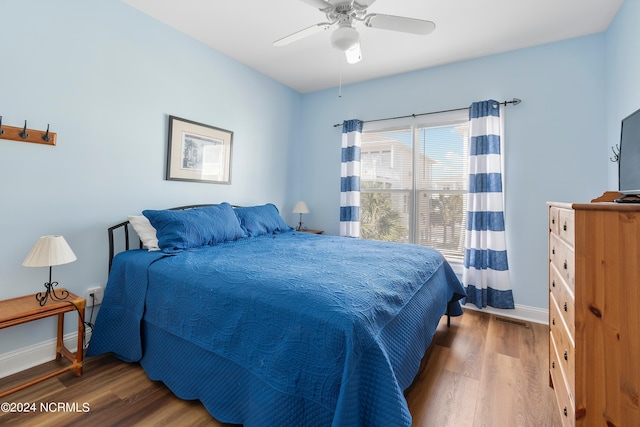 bedroom featuring wood finished floors, visible vents, a ceiling fan, and baseboards