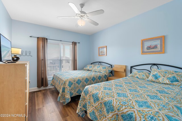 bedroom featuring wood finished floors, a ceiling fan, and baseboards