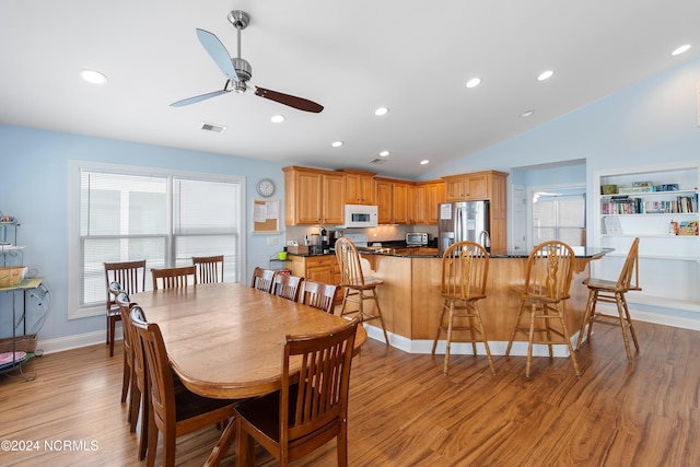 dining space with lofted ceiling, ceiling fan, and light hardwood / wood-style flooring