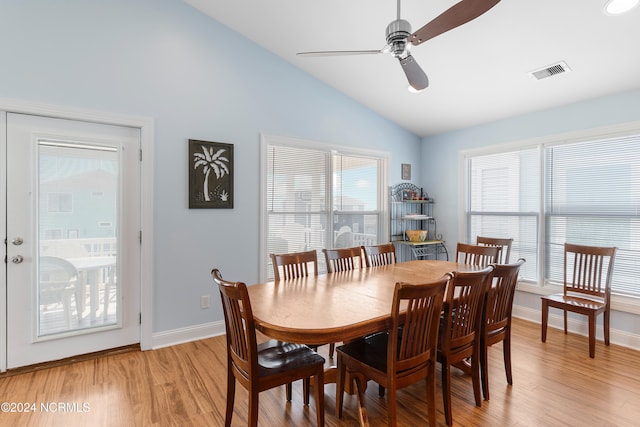 dining room with a ceiling fan, light wood finished floors, baseboards, lofted ceiling, and visible vents