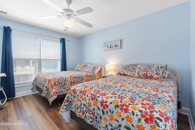 bedroom featuring visible vents, baseboards, a ceiling fan, and wood finished floors