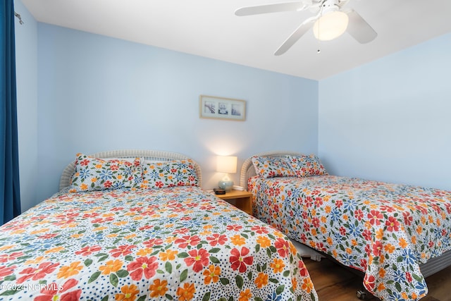 bedroom with dark hardwood / wood-style floors and ceiling fan