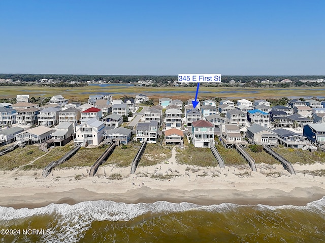 drone / aerial view featuring a beach view and a water view