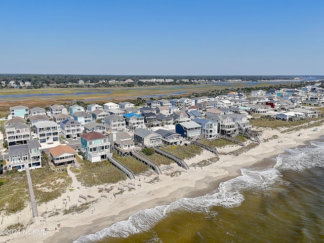 drone / aerial view with a beach view, a residential view, and a water view