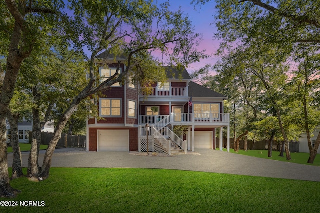 beach home featuring a garage, a lawn, and a porch