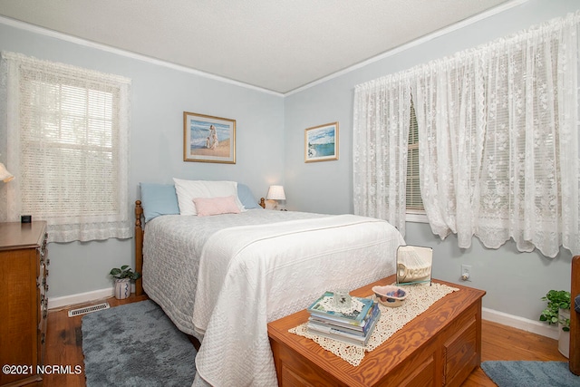 bedroom with wood-type flooring and crown molding