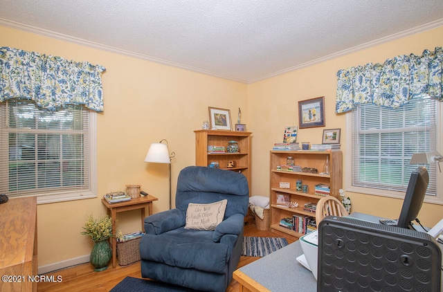 living area with a textured ceiling, crown molding, and hardwood / wood-style floors