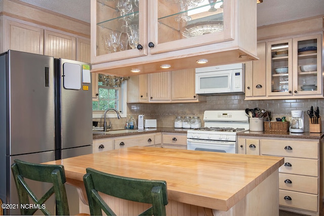 kitchen featuring tasteful backsplash, white appliances, wooden counters, a textured ceiling, and sink