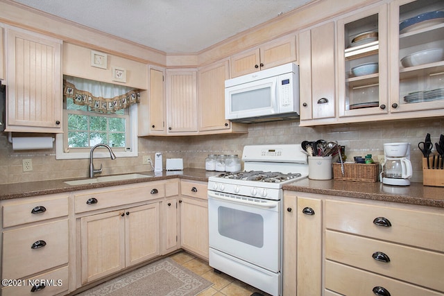 kitchen with tasteful backsplash, sink, white appliances, light brown cabinets, and light tile patterned floors