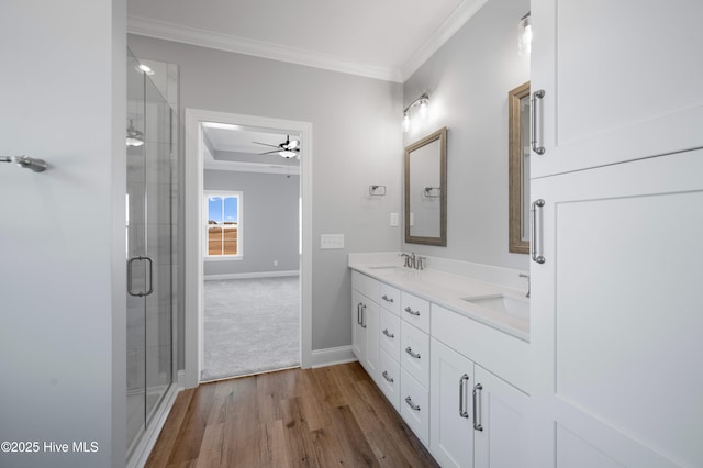 bathroom featuring hardwood / wood-style flooring, crown molding, vanity, and an enclosed shower