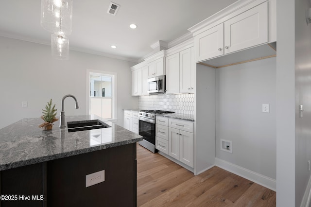 kitchen with white cabinetry, sink, pendant lighting, and appliances with stainless steel finishes