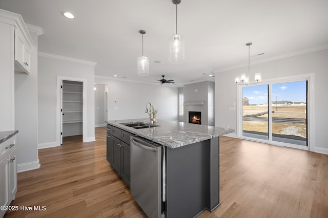 kitchen featuring sink, dishwasher, white cabinetry, a kitchen island with sink, and light stone countertops