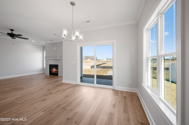 unfurnished living room featuring ornamental molding, ceiling fan with notable chandelier, and light wood-type flooring