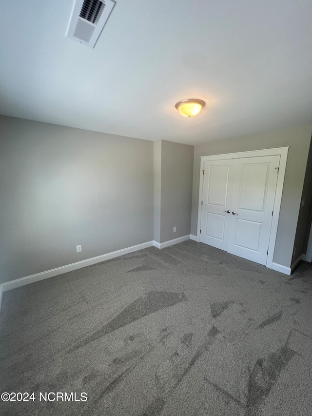 unfurnished bedroom featuring carpet flooring and a closet