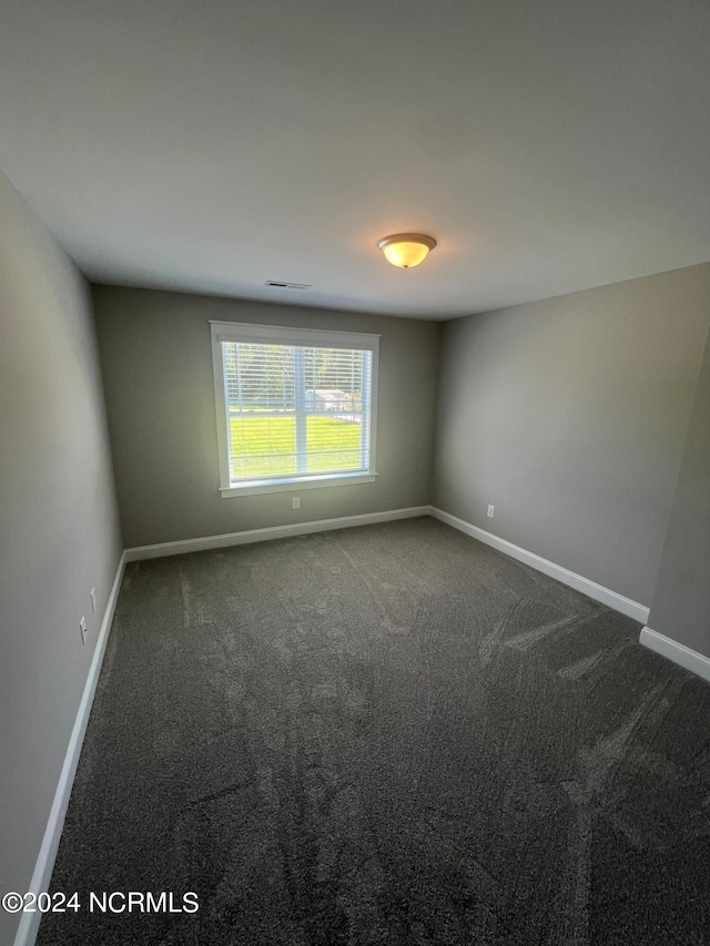 empty room featuring dark carpet