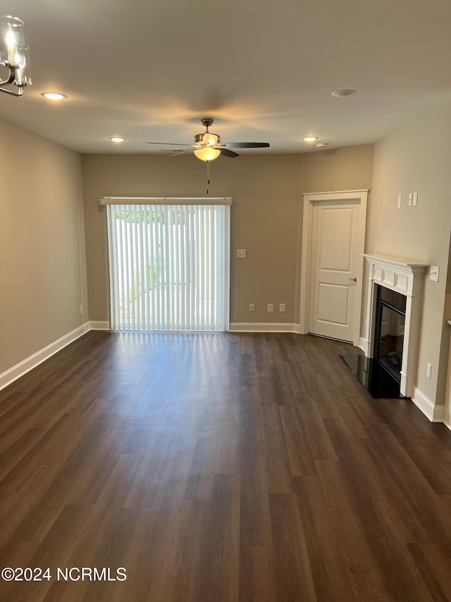 unfurnished living room with ceiling fan and dark wood-type flooring