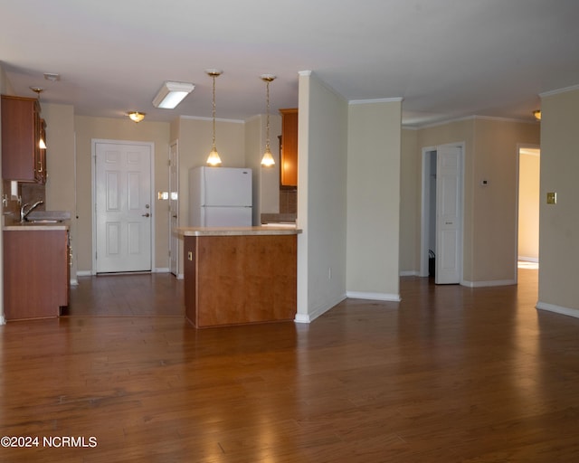 kitchen featuring pendant lighting, white refrigerator, dark hardwood / wood-style floors, and ornamental molding