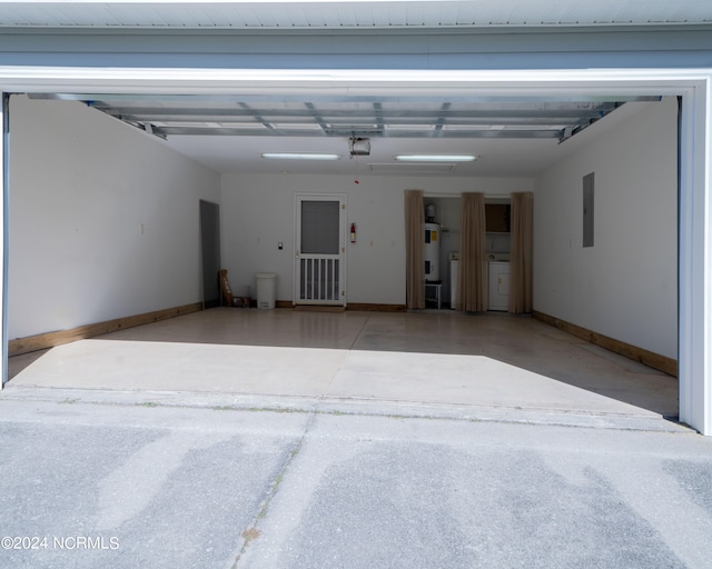 garage featuring washer / clothes dryer, electric panel, and a garage door opener