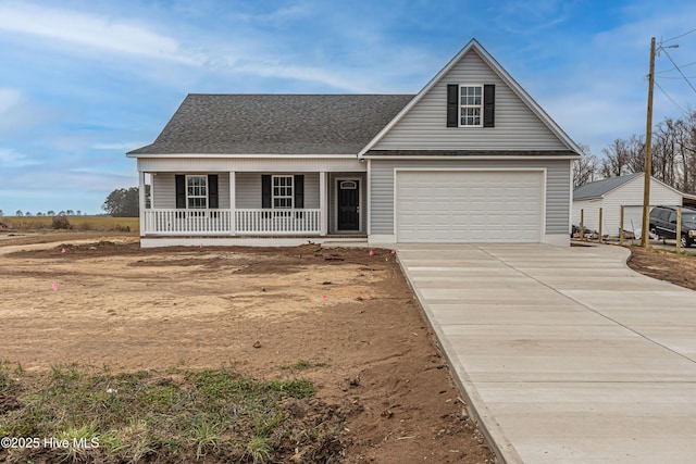 view of front of house with covered porch, driveway, a shingled roof, and a garage